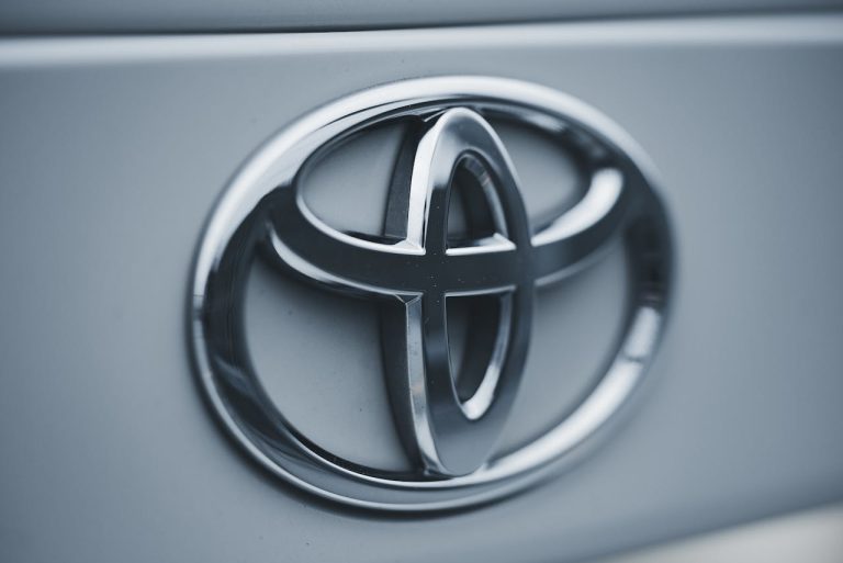 Detailed image of a shiny silver Toyota emblem on a vehicles surface.
